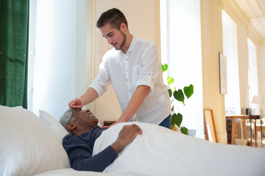 Caregiver assisting elderly in bed