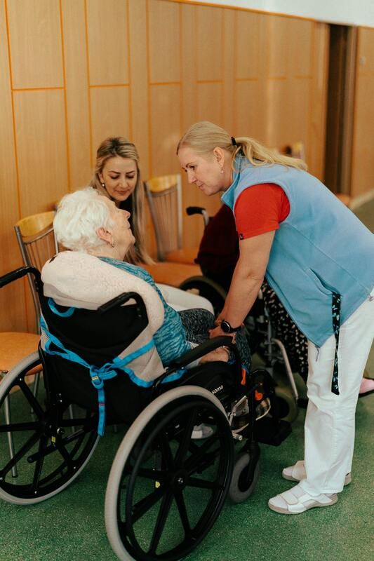 Professional home nurse attending to elderly woman